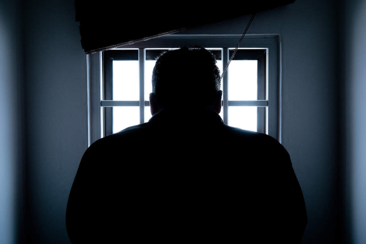person staring out of prison cell