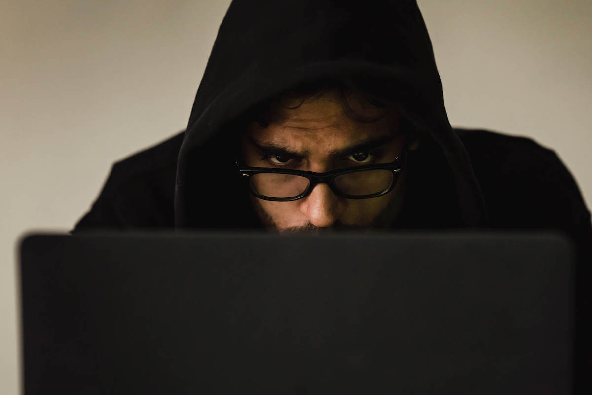 man on laptop wearing black hoodie