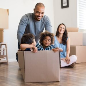 family of four having fun with moving boxes in home