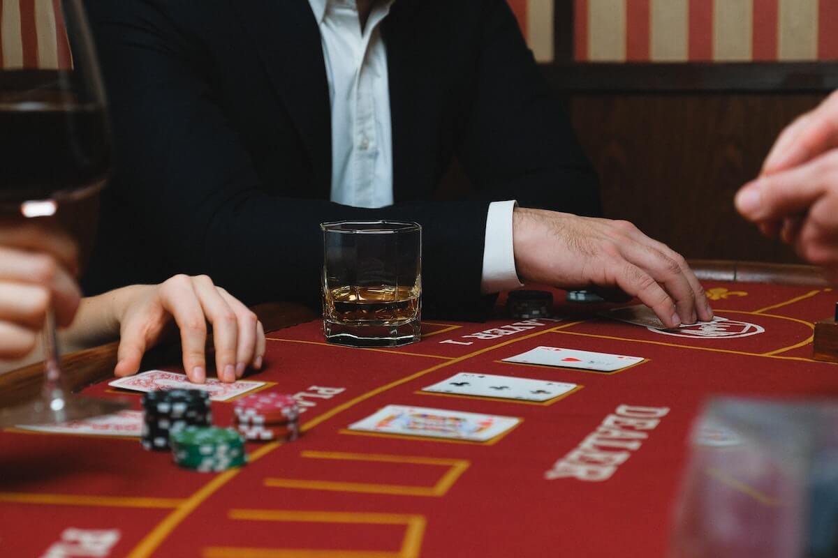 man gambling and drinking at poker table
