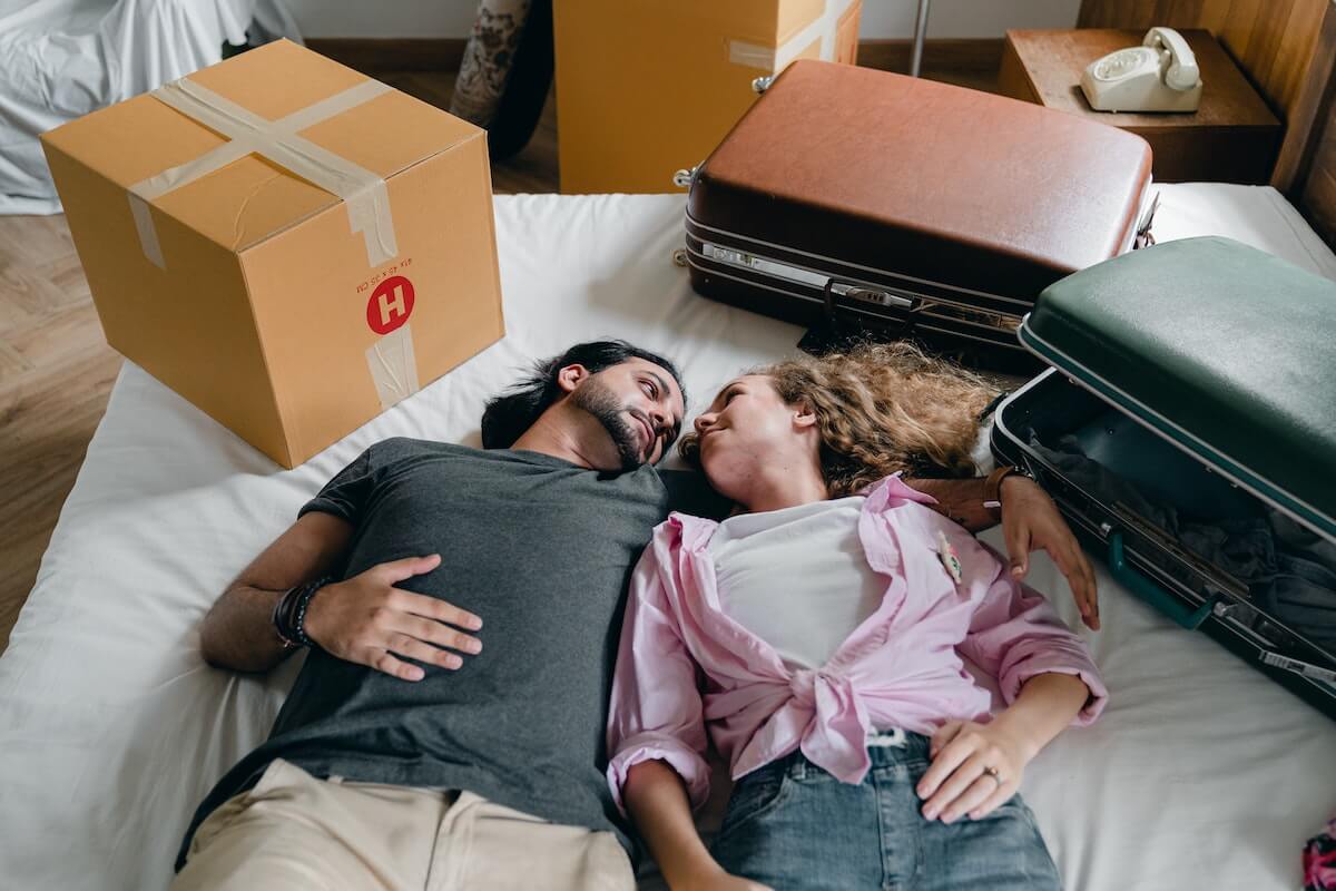 couple relaxing on bed while relocating to new home
